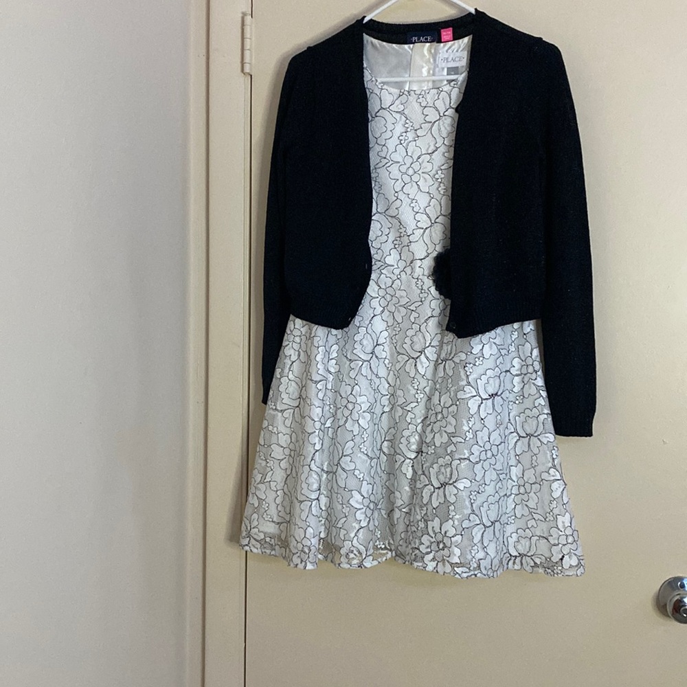 It’s a flower printed material and is black and white with a button sweater